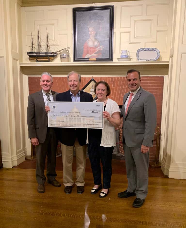 4 People holding up a giant check